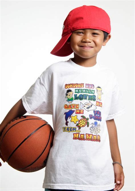 Smiling Young Lad Holding His Basketball Wearing A Red Hat