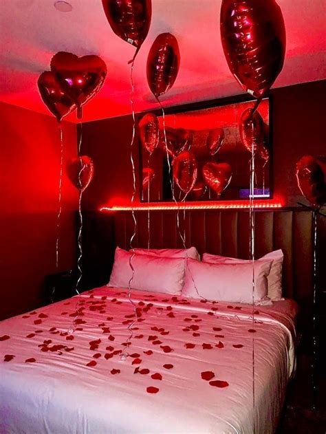 A Bed With Red Lights And Balloons Hanging From Its Headboard In A Bedroom