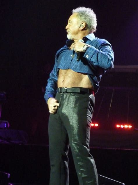 An Older Man Standing On Stage With His Shirt Open
