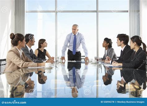 Group Of Business People Having Board Meeting Around Glass Table Stock