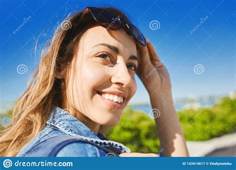 Portrait Of A Young Smiling Attractive Woman With Sunglasses At Sunny Day On The Blue Sky