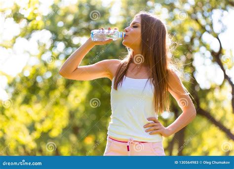 Fitness Beautiful Woman Drinking Water After Exercising At The Park