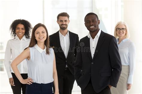 Portrait Of Smiling Diverse Work Team Standing Posing In Office Stock