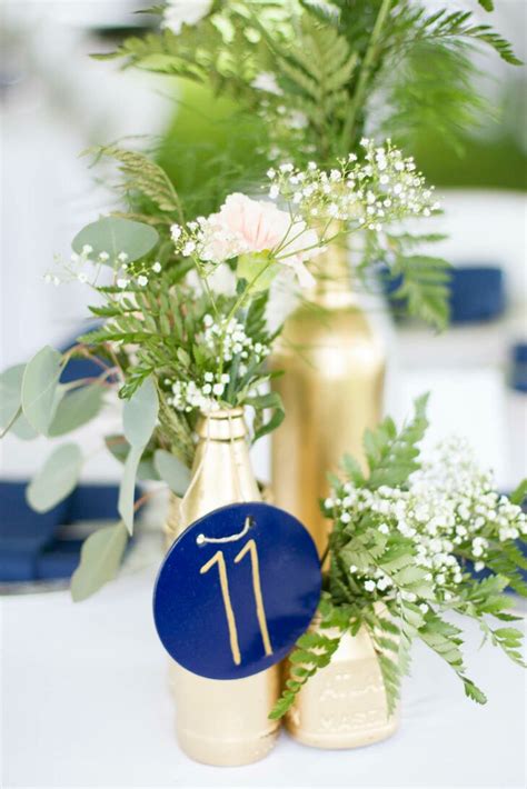 Diy wedding reception floral centerpieces gold painted bottles. DIY Navy, Gold and White Centerpieces