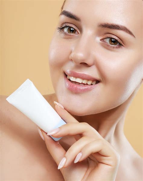 Beautiful Caucasian Woman Face Portrait Holding And Presenting Cream Tube Product Stock Image