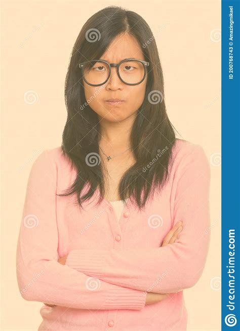 Portrait Of Stressed Young Asian Nerd Woman Looking Angry With Arms