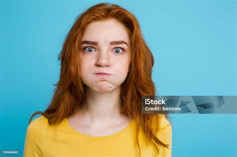 Headshot Portrait Of Happy Ginger Red Hair Girl With Funny Face Looking At Camera Pastel Blue