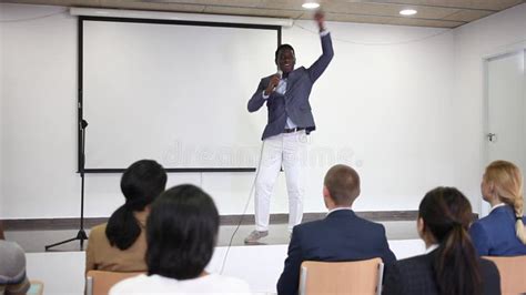 Young Emotional Male Motivation Coach Giving Speech From Speaker Stage