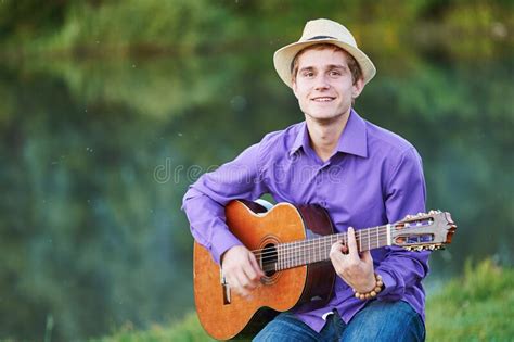 Young Man Guitarist Playing Acoustic Guitar Outdoors Stock Image