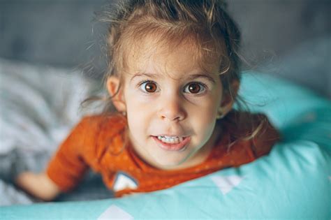 Portrait Of Cute Baby Girl Smiling In Bed And Having Fun Alone Stock