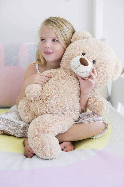 Happy Little Girl Holding Teddy Bear On Bed — Emotion Lifestyle
