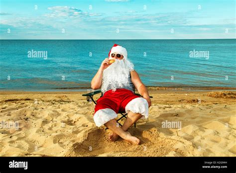 Santa Claus On The Beach Eating A Hamburger The Concept Of Unhealthy