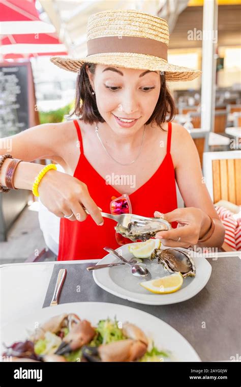 Woman Eating Fresh Oyster In Seafood Mediterranean Restaurant Stock
