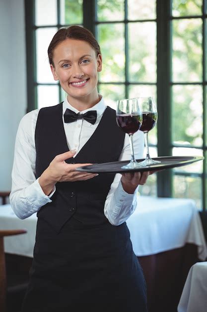Premium Photo Smiling Waitress Holding A Tray With Glasses Of Red Wine