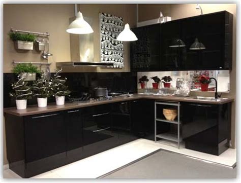 A refrigerator, two counter tops perpendicular to one another, cabinets above and below, a stove, how they all are placed in relation to one another, and the overall aesthetic of the room. Black Colour L-Shaped Kitchen Cabinet