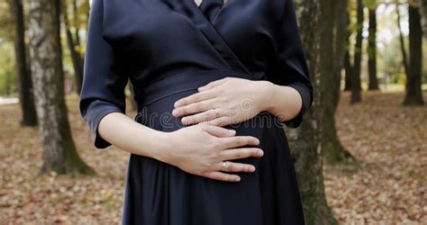 Pregnant Girl Holding Her Hands On Her Stomach Dress In Black Dress Pregnant Belly Close Up