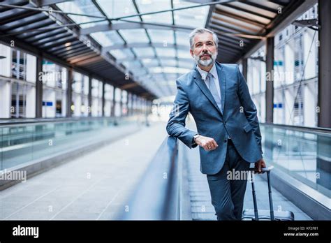 Businessman With Luggage On Moving Walkway Stock Photo Alamy