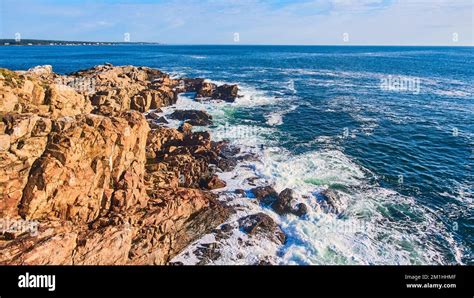 Cliffs Of Ocean In Maine With Waves Crashing Over Boulders Stock Photo