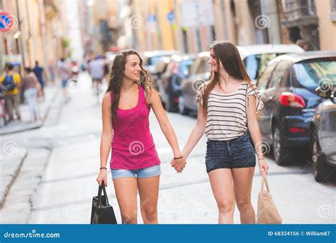 Two Girls Walking On The Street Holding Hands Stock Photo Image Of