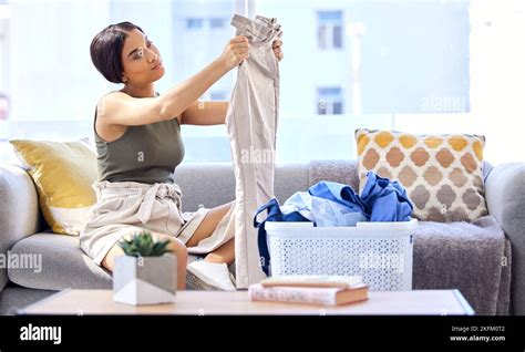 Laundry Housekeeping And Woman Folding Clothes Cleaning And Working In The Living Room Of Her