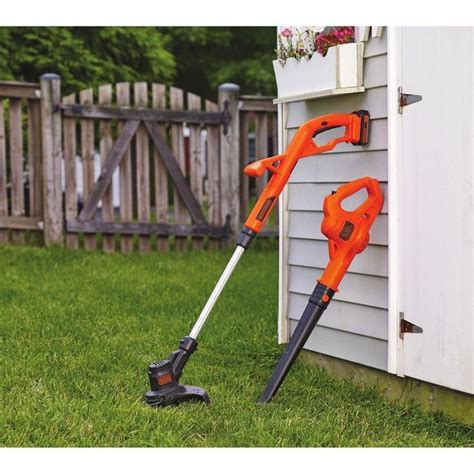 An Orange And Black Lawn Mower Sitting In Front Of A House With The