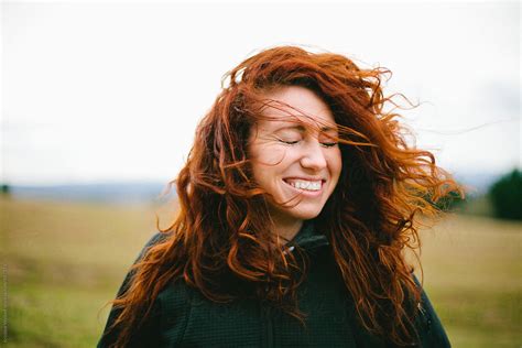 Womans Red Curly Hair Being Blown In The Wind By Stocksy Contributor