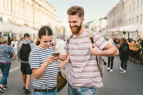Couple Tourists Consulting City And Mobile Phone Gps In Street People