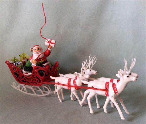 1950 s plastic santa holding present in sleigh with four white reindeer sleigh holds snowman