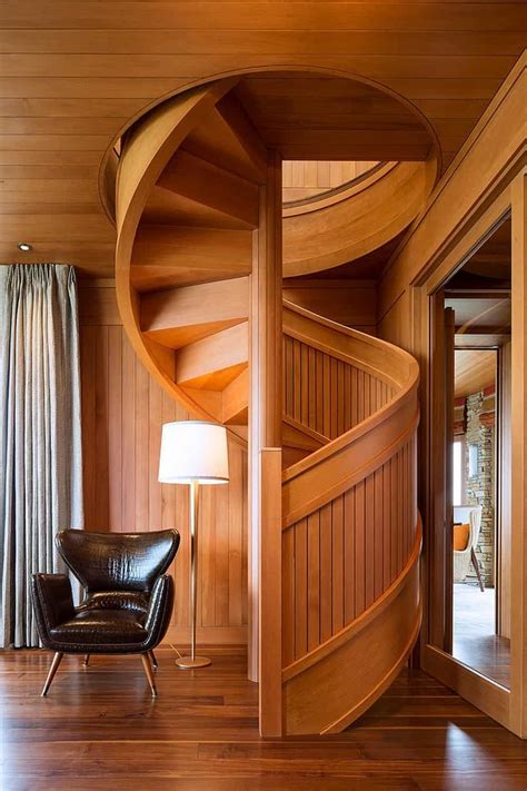 Contemporary home boasting a spiral staircase featuring red carpet steps. Flowing Spiral Wood Staircase is a Work of Art