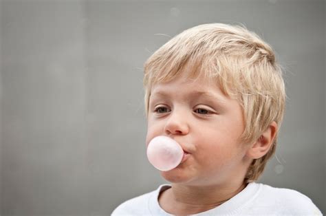 Premium Photo Child Blowing A Bubble Gum