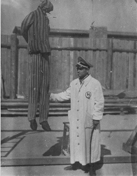 A Man Posing As A Member Of The Ss Stands Next To The Simulation Of An Execution By Hanging
