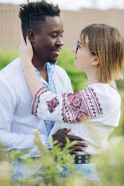 Interracial Couple Embraces In Spring Garden Dressed In Ukrainian