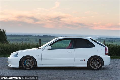a white car parked on top of a gravel road