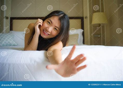 het jonge mooie en gelukkige aziatische chinese vrouw liggen op bed in het ochtend thuis