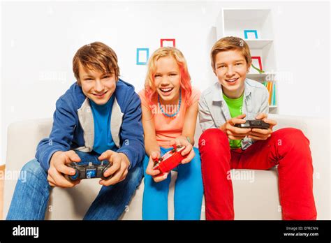 Happy Teens Hold Joysticks And Play Game Console Stock Photo Alamy