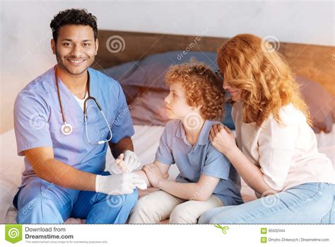 Positive Delighted Medical Worker Treating Injured Hand Stock Photo