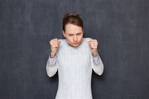 Portrait Of Funny Angry Small Woman Raising Clenched Fists Stock Photo