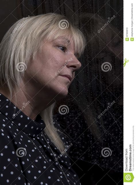 woman indoors looking out of a window stock image image of window worried 87363813