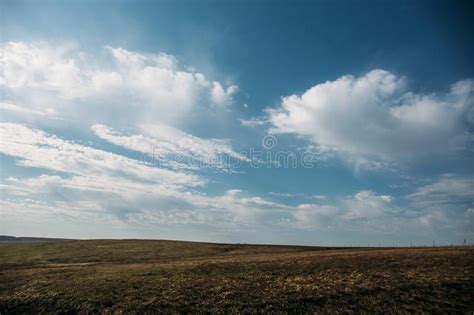 Hill And Plain Landscape Field Of Spring Grass And Dramatic Blue Sky