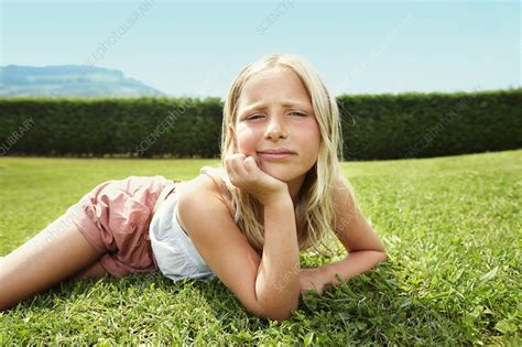curious girl laying in grass stock image f004 9701 science photo library