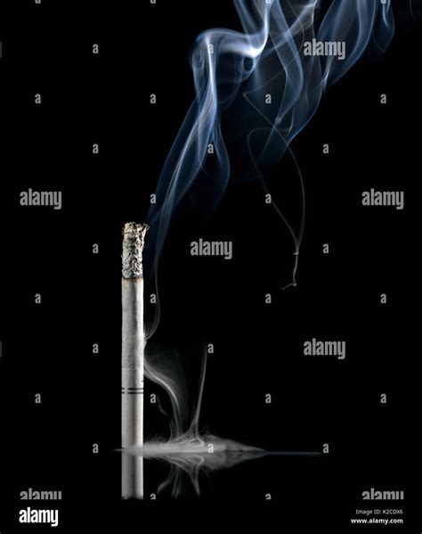 White Lit Cigarette On A Black Background With Lots Of Smoke Coming