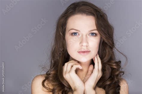 Beautiful Brunette Woman With Blue Eyes Without Make Up Natural Flawless Skin And Hands Near