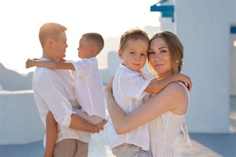 Familia Feliz De Vacaciones En Santorini Grecia Los Padres Sostienen A