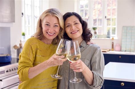 Portrait Of Same Sex Mature Female Couple Celebrating With Glass Of