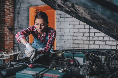 Female mechanic repairing car engine at garage - Stock Photo - Dissolve