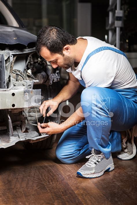 Young Mechanic Fixing Car At Auto Repair Shop Stock Photo Royalty