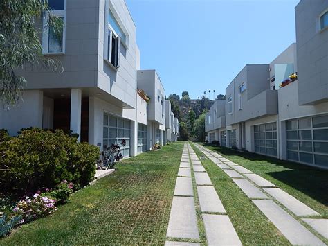 A Modern Townhouse Complex With Large Plank Pavers And Grass Crete