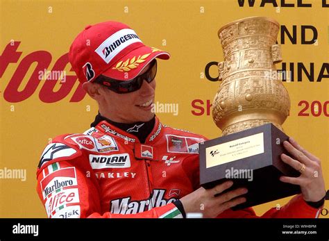 Australian Racer Casey Stoner Looks At The Champion Trophy After He Won