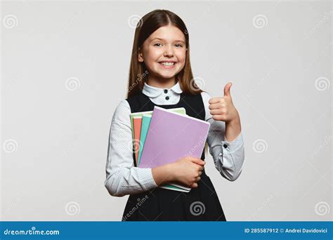 Happy Sweet School Girl With Notebooks Looking At Camera With Smile And