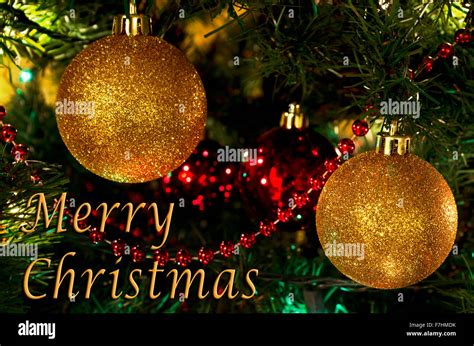 Sparkling Gold Ball Ornaments On A Christmas Tree With A Merry